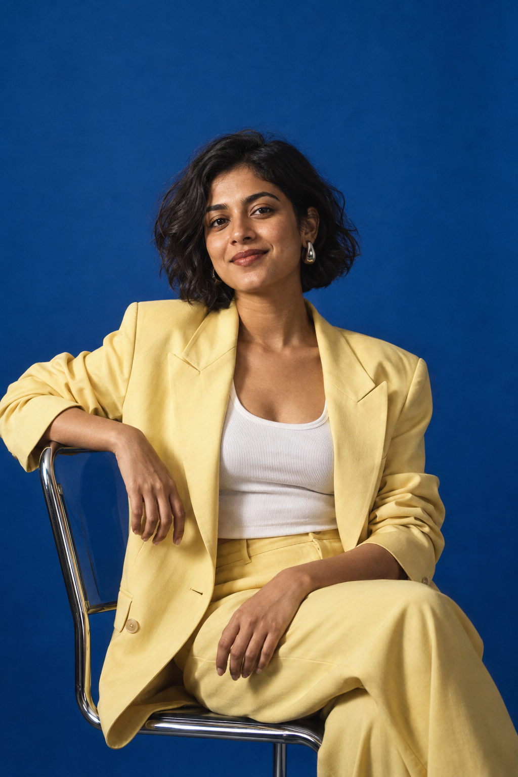 Campaign portrait of a woman in a butter-yellow blazer against an ultramarine backdrop